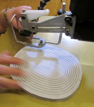 Cutting the bowl following a pattern drawn on the wood